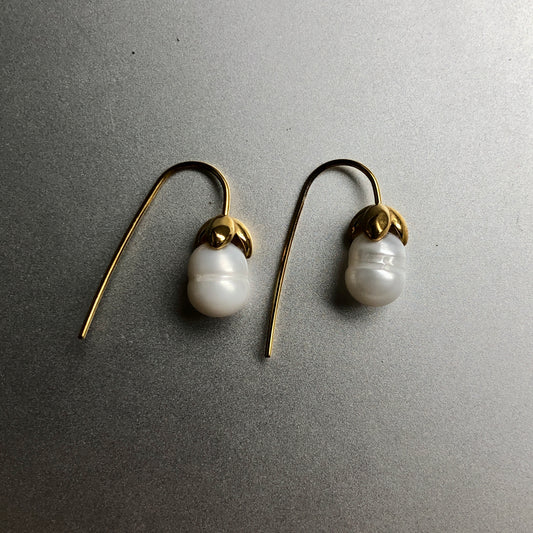 Baroque Pearl Drops – weiße Süßwasserperlen an gebogenen goldfarbenen Ohrhaken – Paar auf hellem Hintergrund